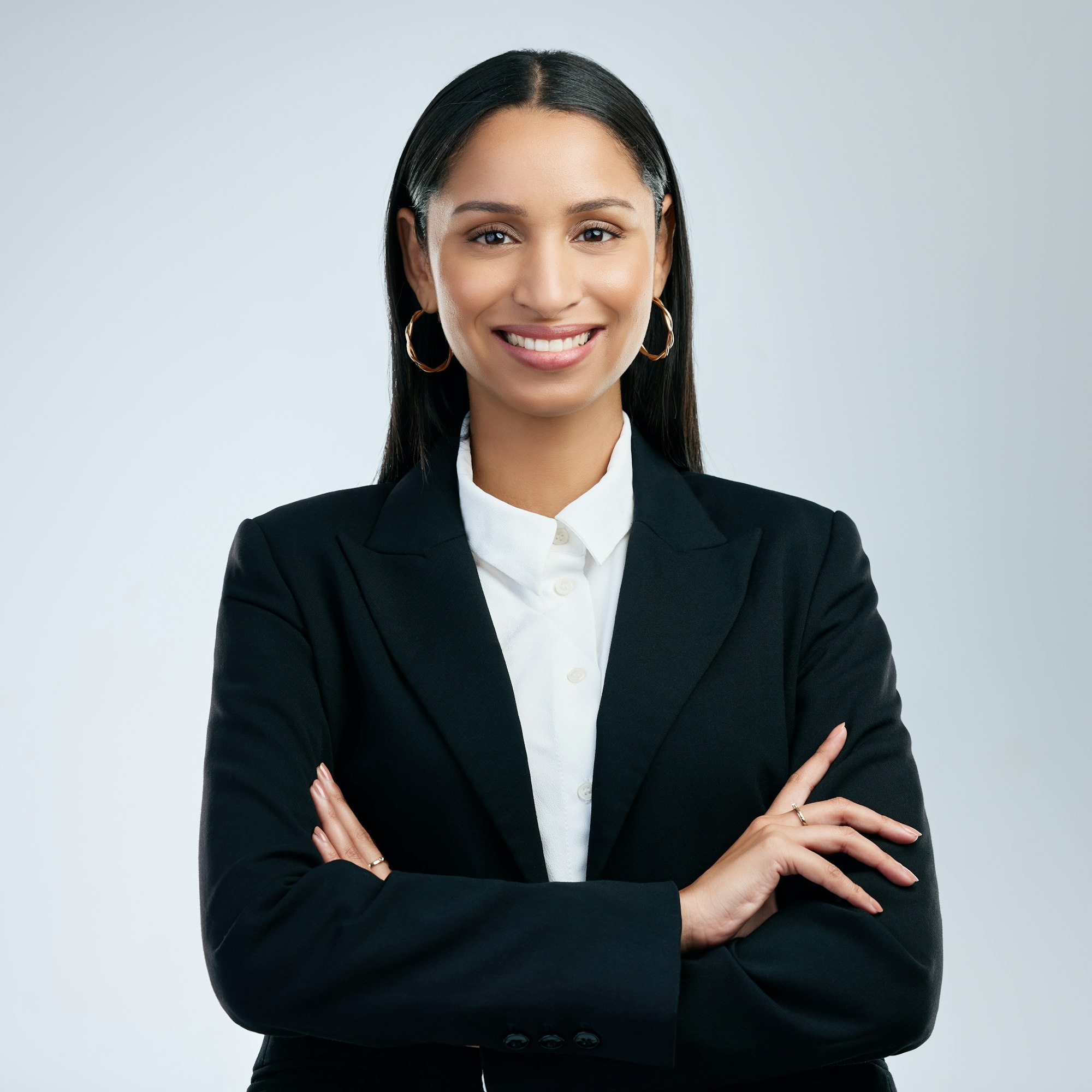 shot of a confident young businesswoman standing against a grey background